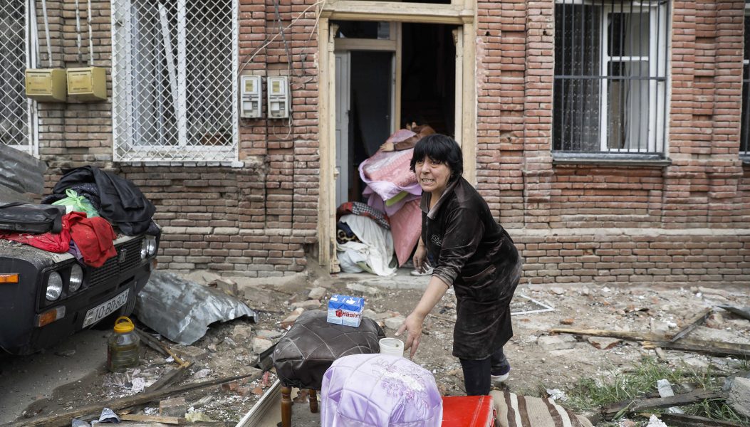 Armeniska styrkor har skjutit sönder hennes hem och nu räddar hon sina saker.