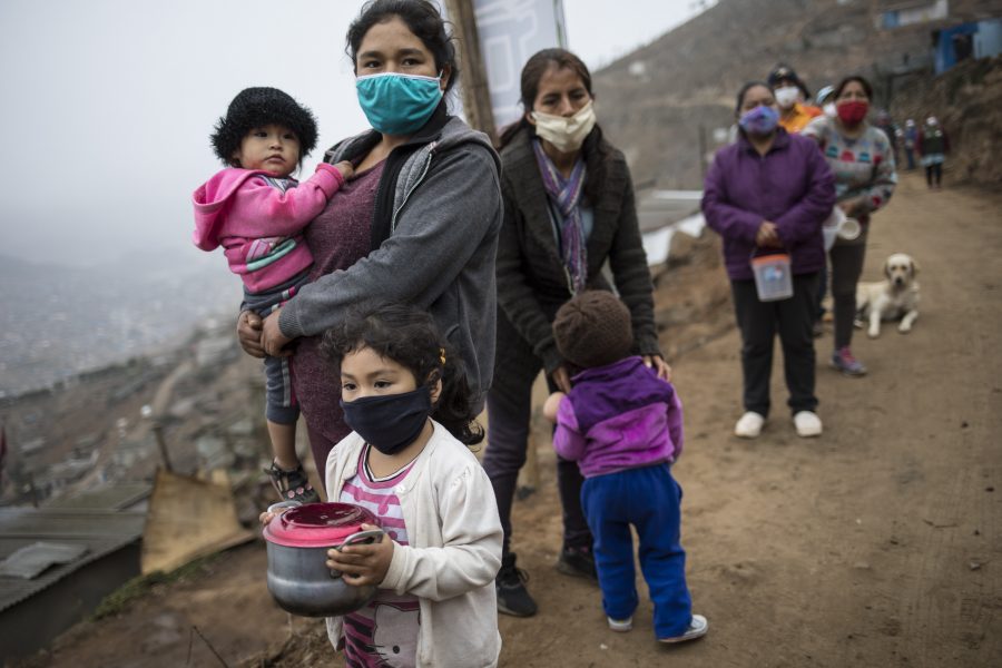 Människor köar för att få ett gratis mål mat utanför Perus huvudstad Lima, en av de många platser på jorden där det nya coronaviruset fått förödande konsekvenser för de fattiga.