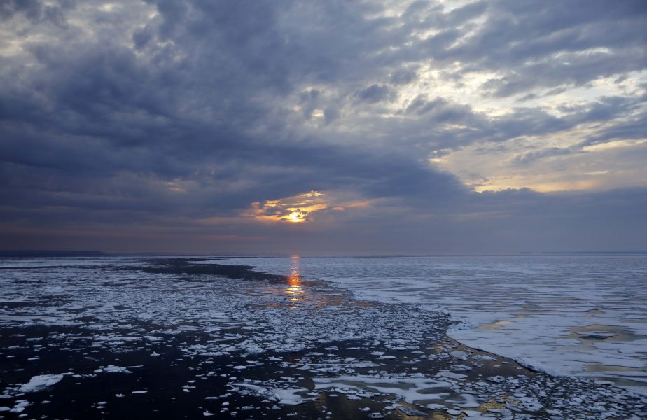 Solen sänker sig över havsisen i norra Kanada.