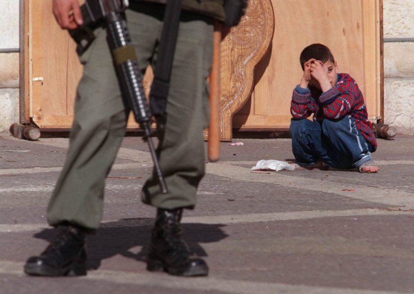 Ett palestinskt barn och en israelisk gränspolis.
