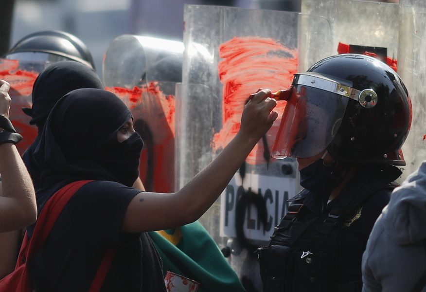 En demonstrant i Mexico City målar på en polishjälm under en aktion till stöd för protesterna i Cancún.