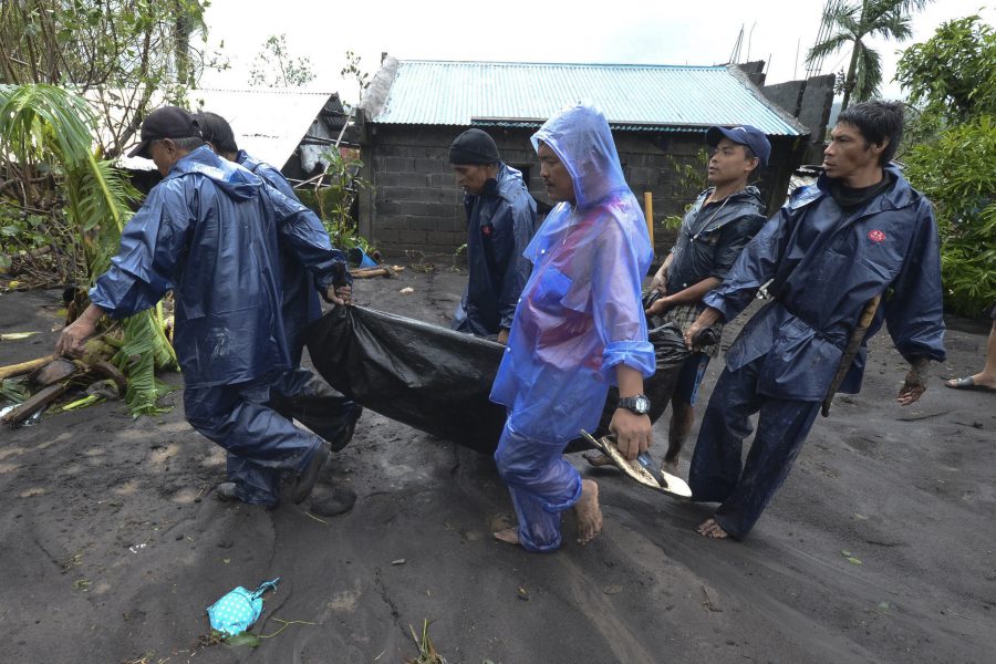 Räddningsarbetare bär en man som drunknade när tyfonen Goni drog fram över Guinobatan i den filippinska provinsen Albay.