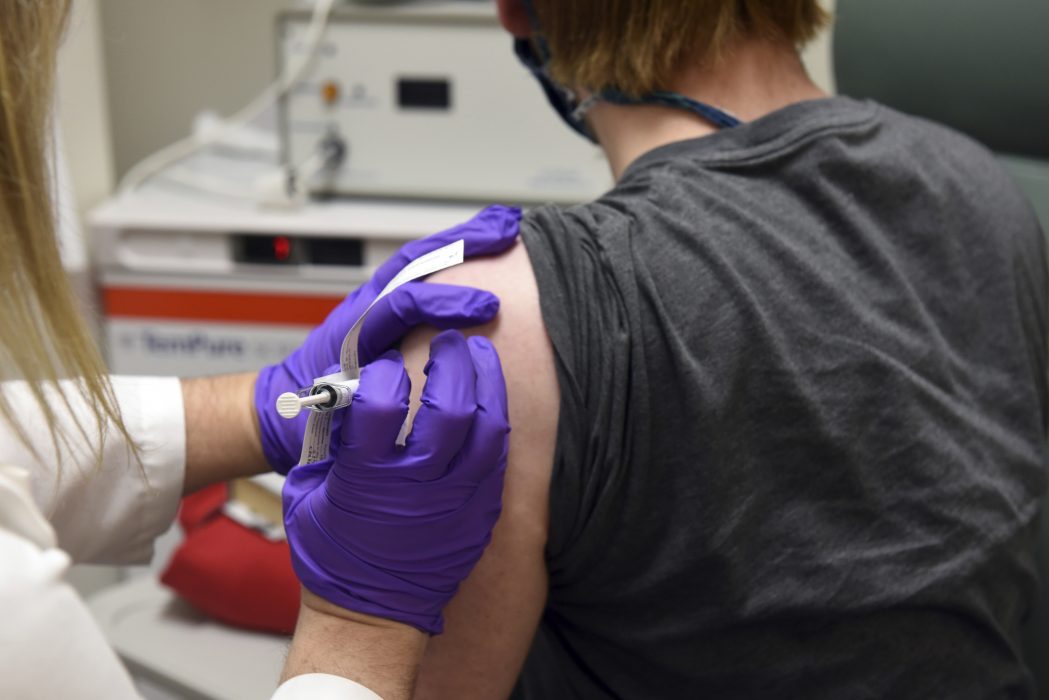 En försöksperson får covidvaccin från Pfizer.