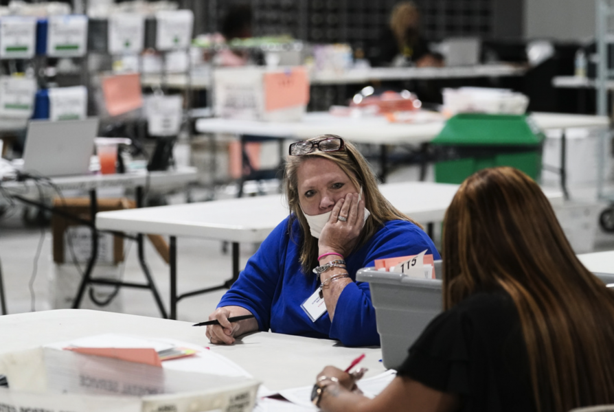 Rösträknare i Arizona väntar in nästa omgång valsedlar att räkna.