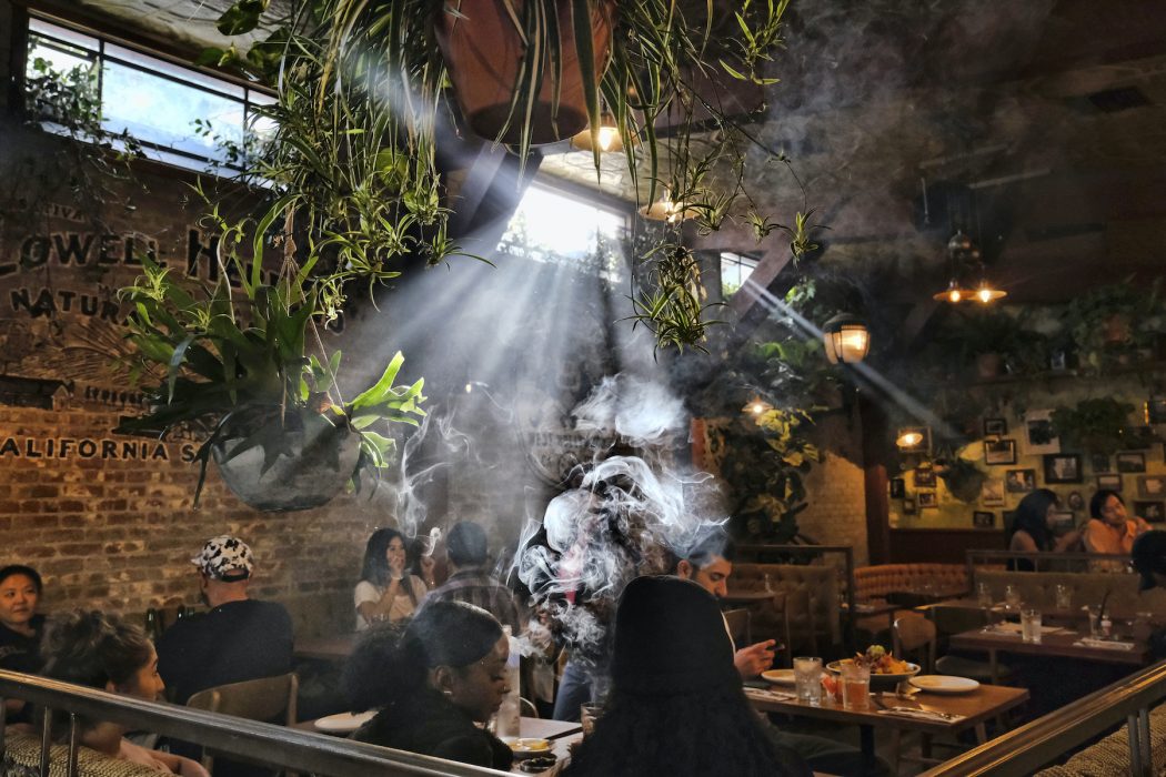 Människor syns röka marijuana på Lowells original cannabis cafe i USA.