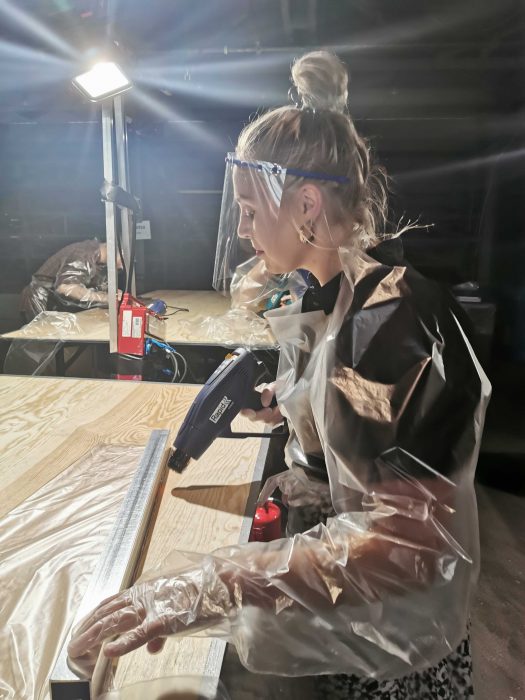 Volonyätrn Felicia Rosén fixar ärmar till skyddskläderna i förklädesfabriken