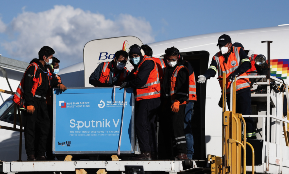 Flygplatspersonal i Bolivia tar emot landets första leverans av det ryska vaccinet Sputnik V.
