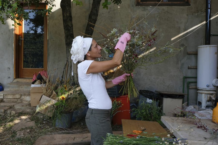 Yasmina Zaher binder blommor odlade på marken som hon tagit över tillsammans med sin partner.