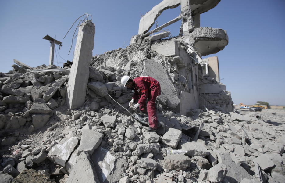 En räddningsarbetare letar överlevande i ruinerna efter en saudisk-ledd flygbombning i Jemen.