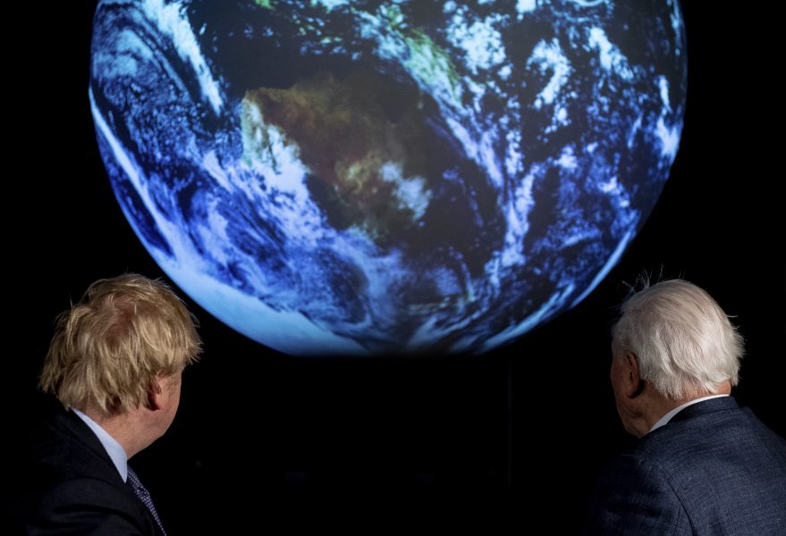 Storbritanniens premiärminister Boris Johnson och tv-profilen David Attenborough tittar på en projektion av jorden under ett förberedande möte till klimattoppmötet COP26 som går av stapeln i november.