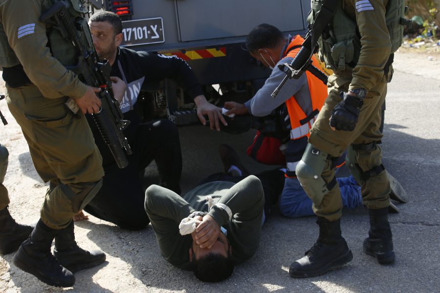 En skadad palestinsk demonstrant omhändertas efter att ett militärfordon kört över honom vid en demonstration utanför en bosättning på Västbanken.