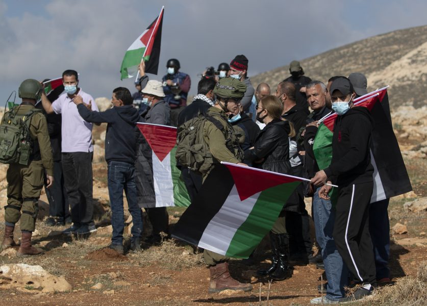 Israeliska soldater hindrar palestinska demonstranter från att nå en bosättning på Västbanken.