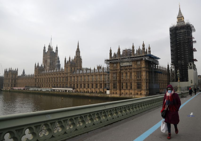 En kvinna går över Westminster Bridge under fredagen, samma dag som nya regler för resenärer till England meddelas.