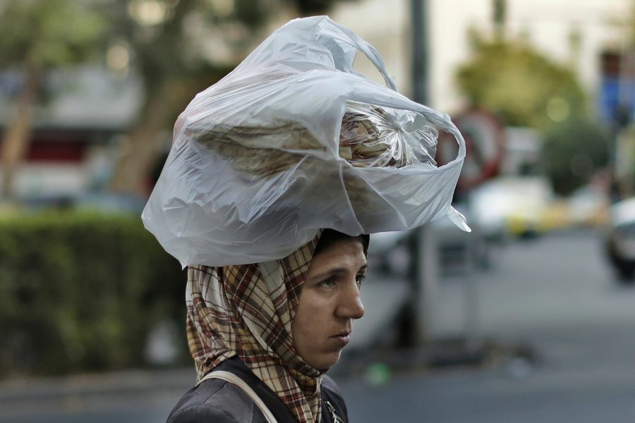 En kvinna bär hem bröd i Syriens huvudstad Damaskus.