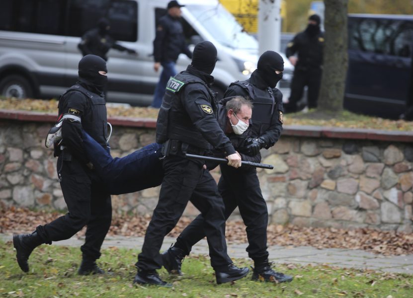 En man bärs iväg i armar och ben vid en demonstration i Minsk, den 1 november i fjol.