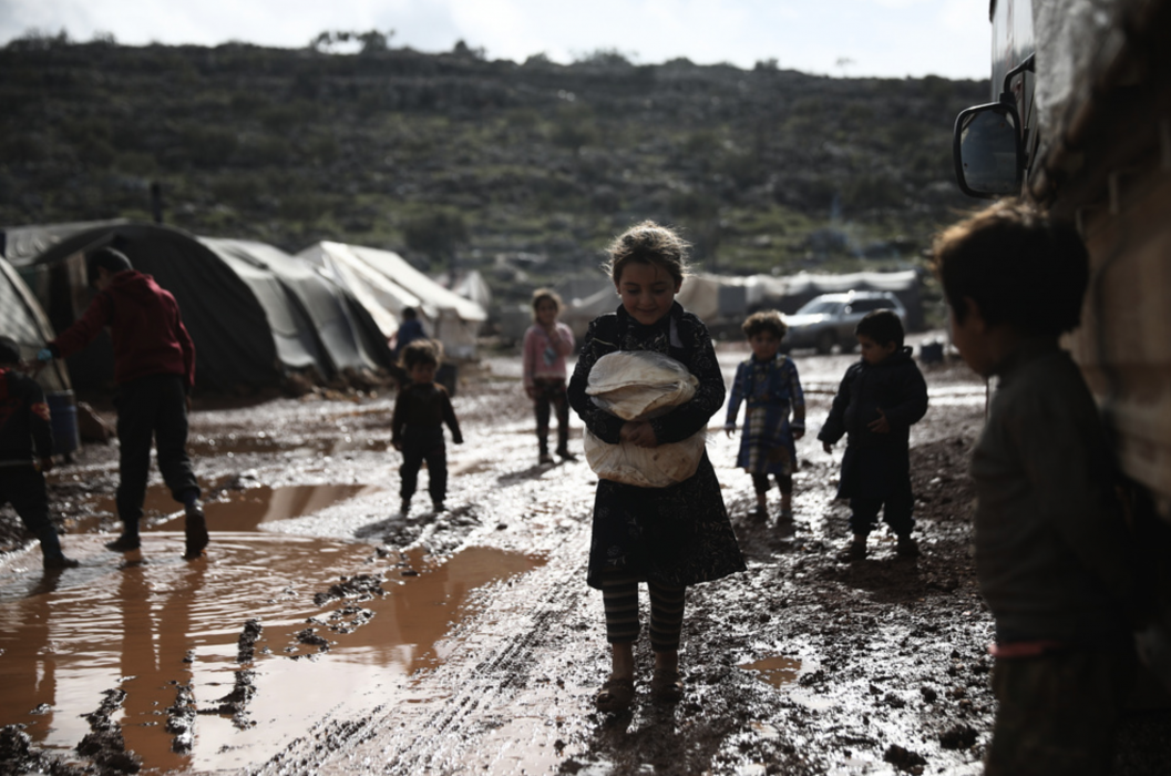 Barn leker i ett lerigt flyktingläger i Idlibprovinsen i Syrien i slutet av januari.