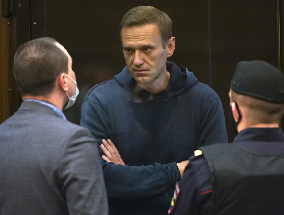 Aleksej Navalnyj talar med en av sina advokater under tisdagens rättegång i Moskva.