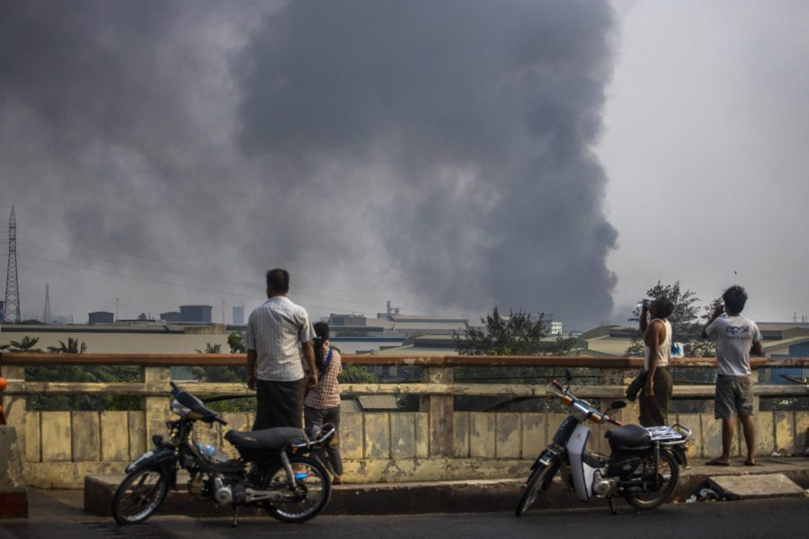 Svart rök stiger mot himlen från de eldhärjade kinesiska textilfabrikerna i Hlaing Tharyar-distriktet i Rangoon, Myanmar.