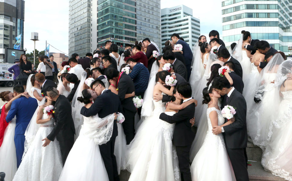 Kinesiska brudpar vid en specialarrangerad gruppvigsel i den populära semesterdestinationen Busan i Sydkorea.