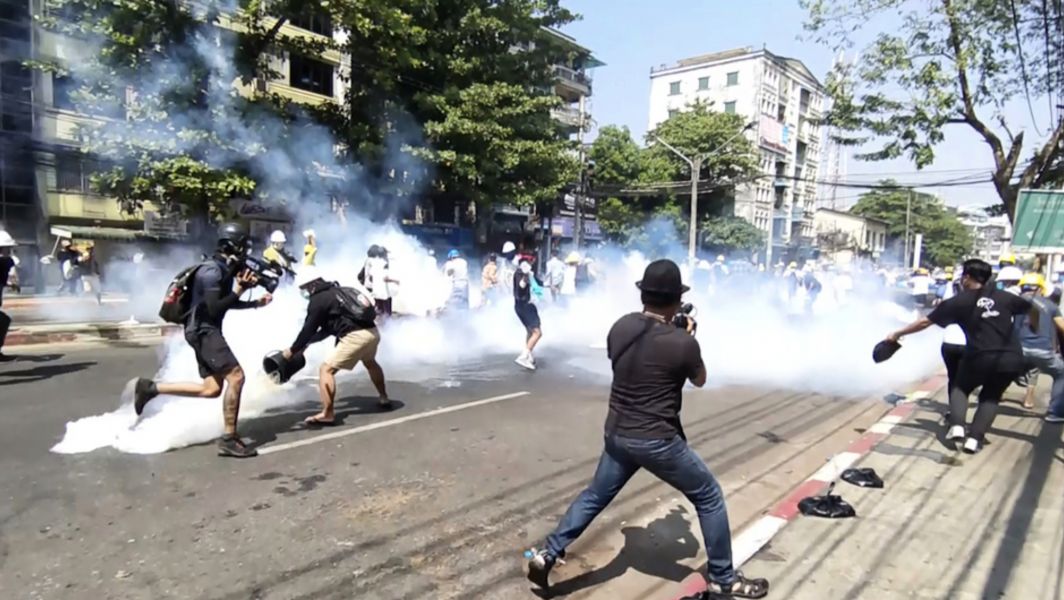 Polis i Rangoon använder tårgas mot demonstranter på måndagen.