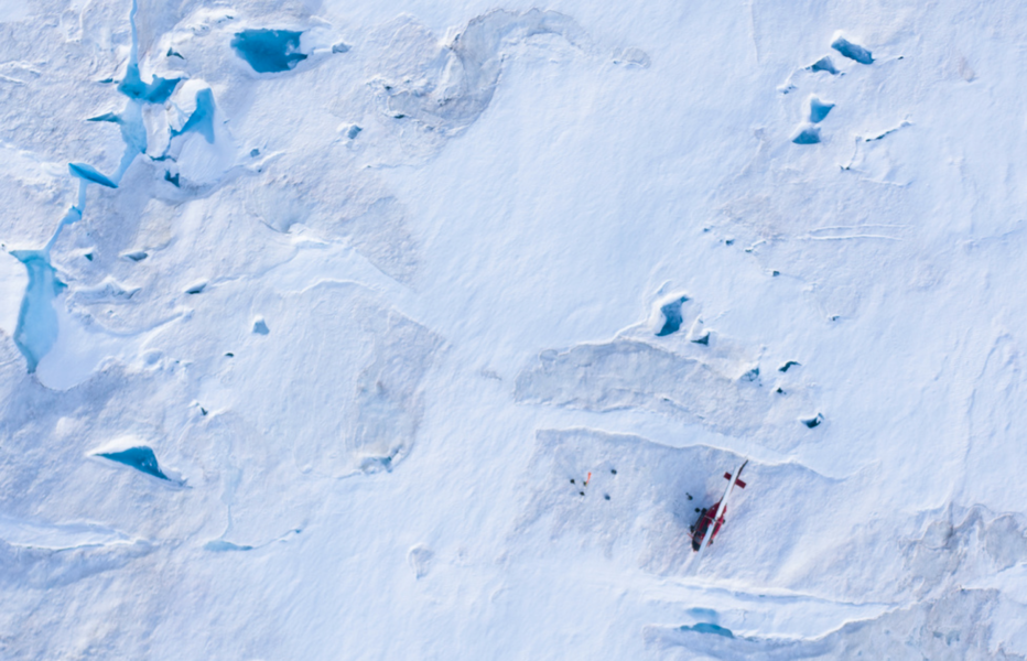 Forskare runt en helikopter, nere till höger i bild, på den grönländska Helheim-glaciären.