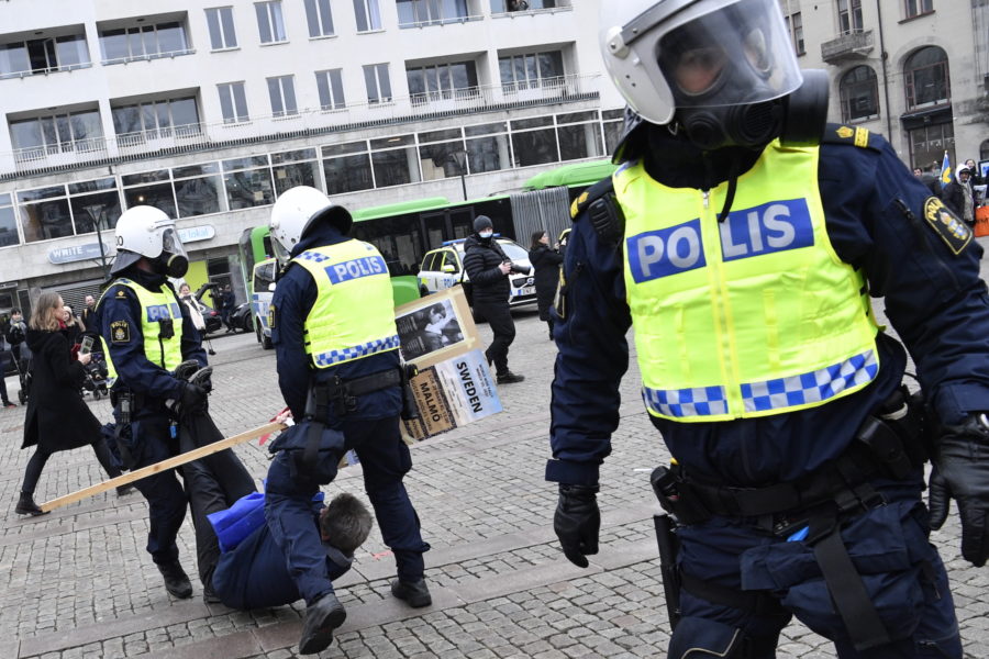 Poliser förde undan demonstranter under lördagens demonstration mot coronarestriktionerna och den svenska coronastrategin på Gustaf Adolfs Torg i Malmö.