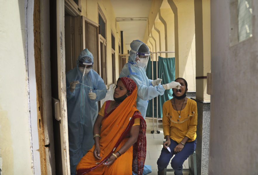 Sjukvårdspersonal covidtestar invånare i New Delhi under fredagen.
