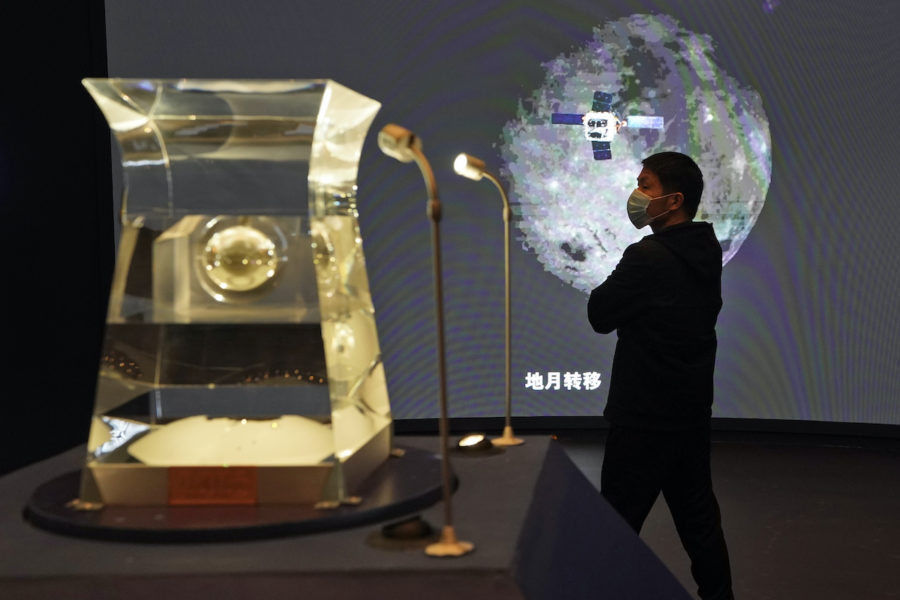En besökare på Kinas nationalmusem begrundar en månsten från Kinas Chang é 5 månexpedition.