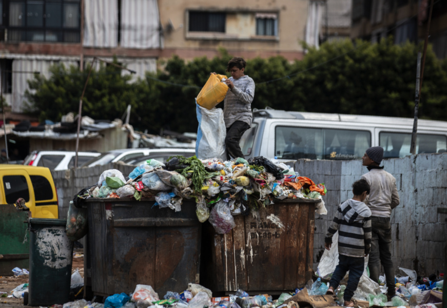 Barn letar efter något av värde i soporna bredvid en marknad i Beirut.