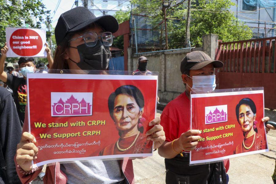 Demonstranter håller upp bilder av den frihetsberövade ledaren Aung San Suu Kyi under en demonstration i Rangoon (Yangon) under onsdagen.