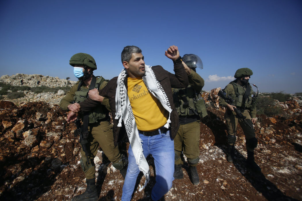 Israeliska soldater griper en palestinier som protesterar mot att en israelisk bosättning tar mer mark på Västbaken, Salfit, november 2020.