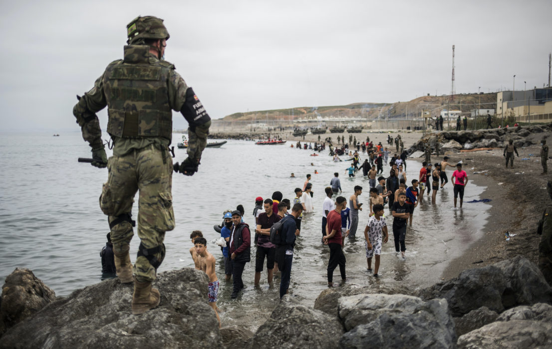 Människor som har simmat eller vadat till Ceuta står i vattnet sedan gränsområdet i den spanska enklaven spärrats av.