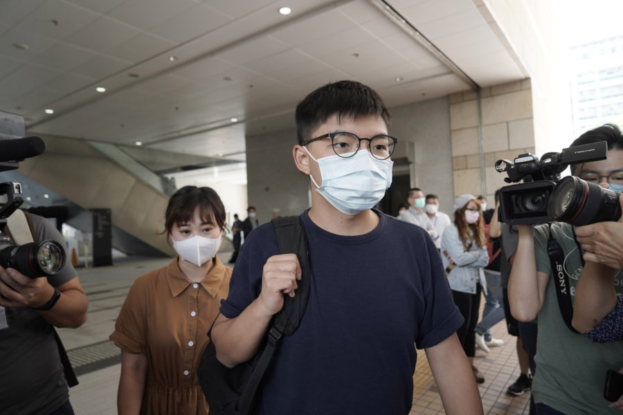 Aktivisten Joshua Wong, i mitten av bilden, tillsammans med aktivisten Tiffany Yuen Ka-wai, till vänster, på väg in till en rättegångsförhandling i Hongkong i oktober förra året.