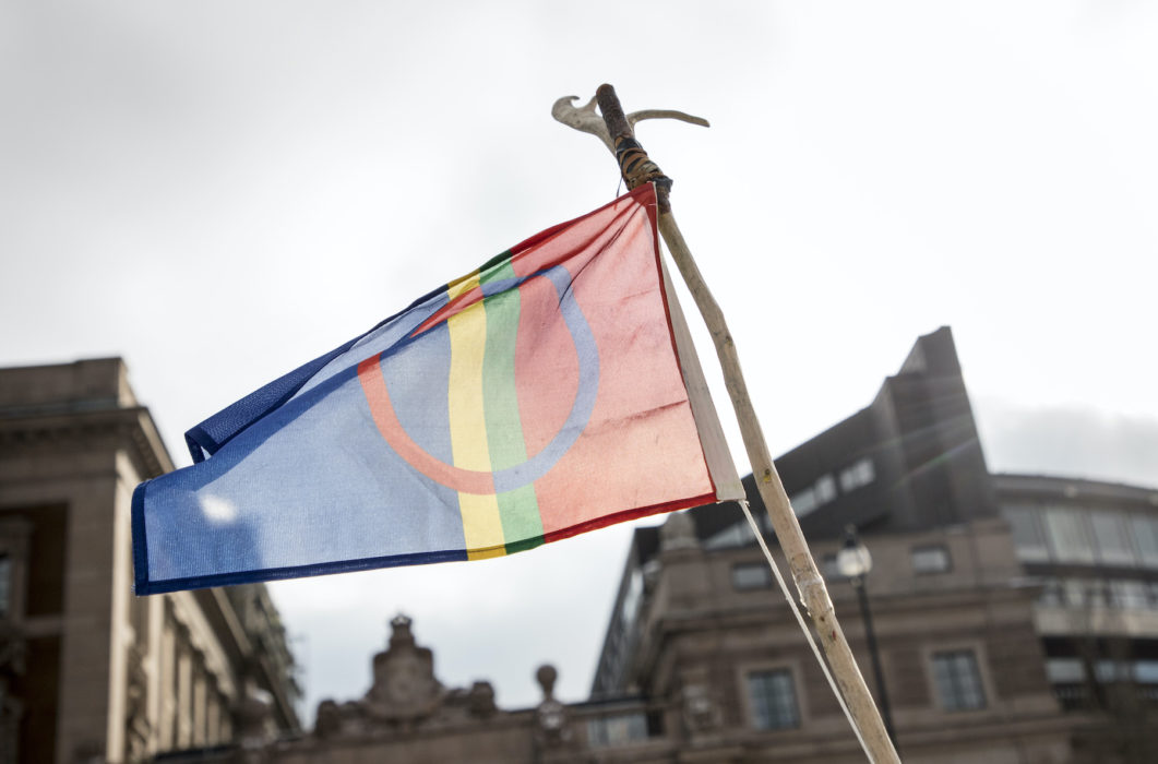 Den samiska flaggan framför Sveriges riksdag.