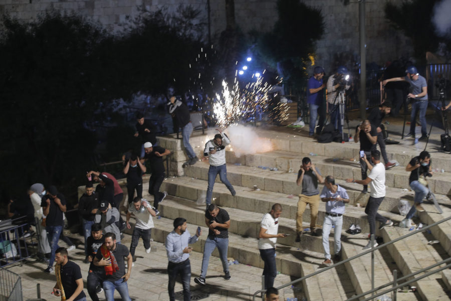 Människor flyr från polisens distraktionsgranater vid Damaskusporten precis utanför Jerusalems gamla stad på lördagskvällen.