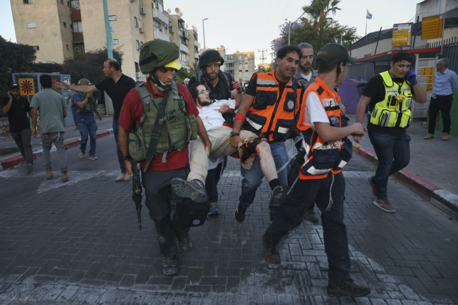 En skadad judisk man bärs iväg av sjukvårdspersonal efter torsdagens våldsamma sammandrabbningar i staden Lod.