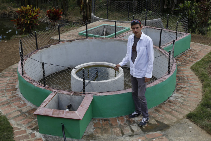 Ingenjören Alexander López Savrán står bredvid en biogasanläggning som han har installerat på sitt jordbruk i byn La Macuca.