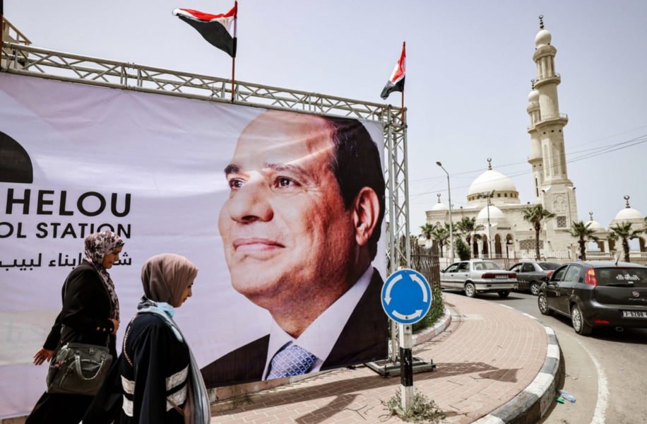 Palestinier går förbi en av de jättebilder av Egyptens president Abd al-Fattah al-Sisi som sattes upp i Gaza City i helgen.