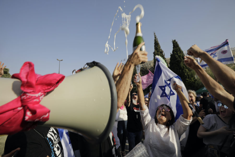 Folk firar efter beskedet att Israels parlament röstat igenom den nya regeringen.
