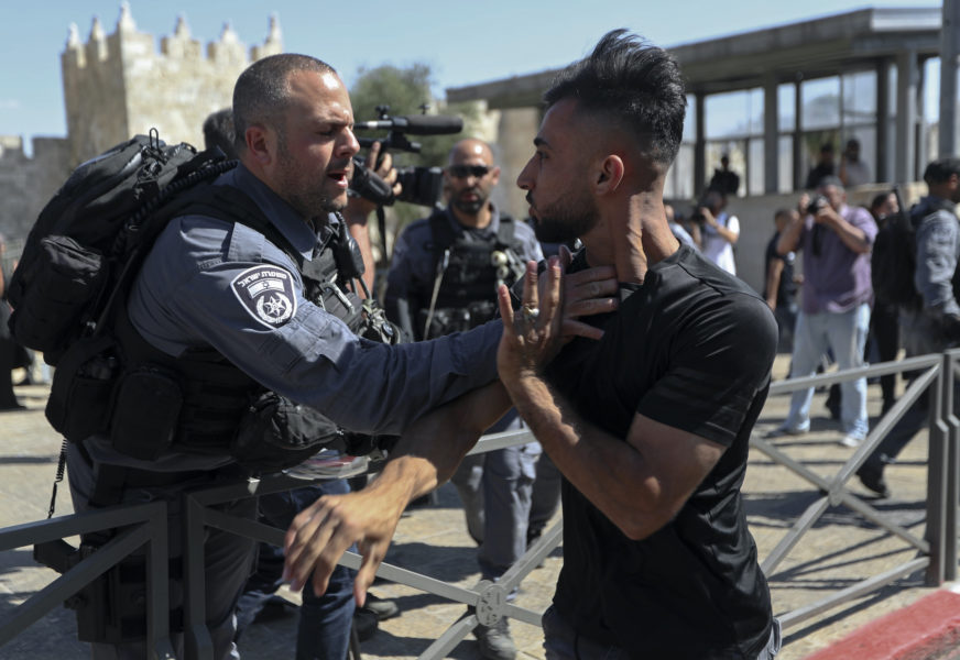 En palestinsk man avvisas av israelisk polis nära Damaskus-porten där tisdagens marsch är planerad att passera.
