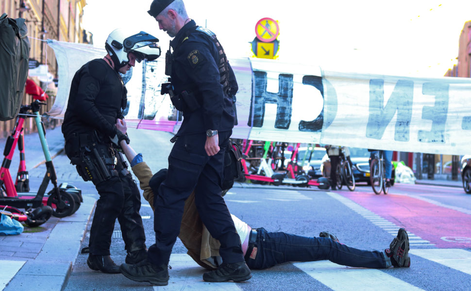 Polis släpar bort en aktivist i samband med en klimataktion på Hornsgatan i Stockholm i helgen.