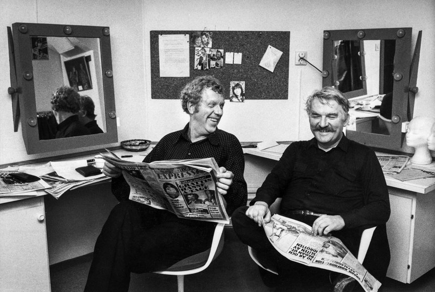 Tage Danielsson och Hasse Alfredsson läser recensionerna av sin revy ”Under dubbelgöken” som spelades på Berns i Stockholm 1979.