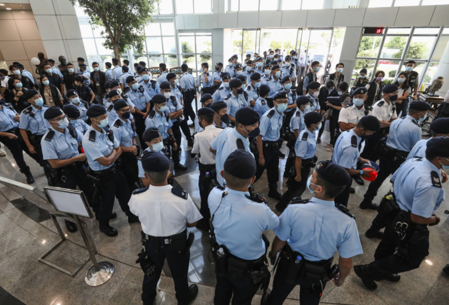 Poliser i Hongkongs ledande prodemokratiska dagstidning Apple Dailys lobby vid ett tillslag den 17 juni.