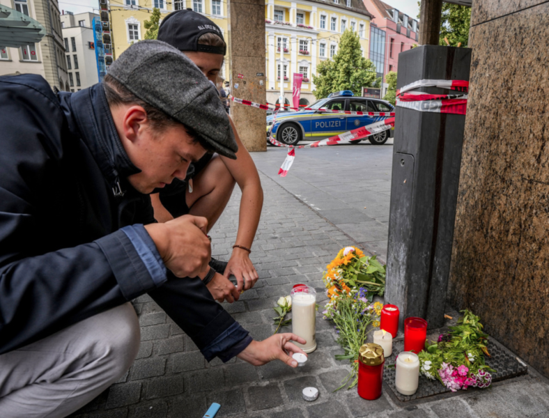 Blommor och ljus på brottsplatsen i Würzburg i Tyskland, där flera personer dödades i ett knivdåd i fredags.