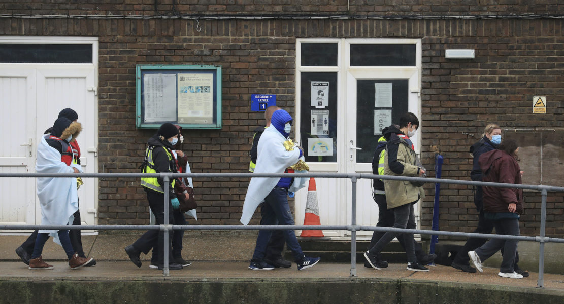 En grupp migranter eskorteras av brittisk gränspolis efter att ha korsat Engelska kanalen.