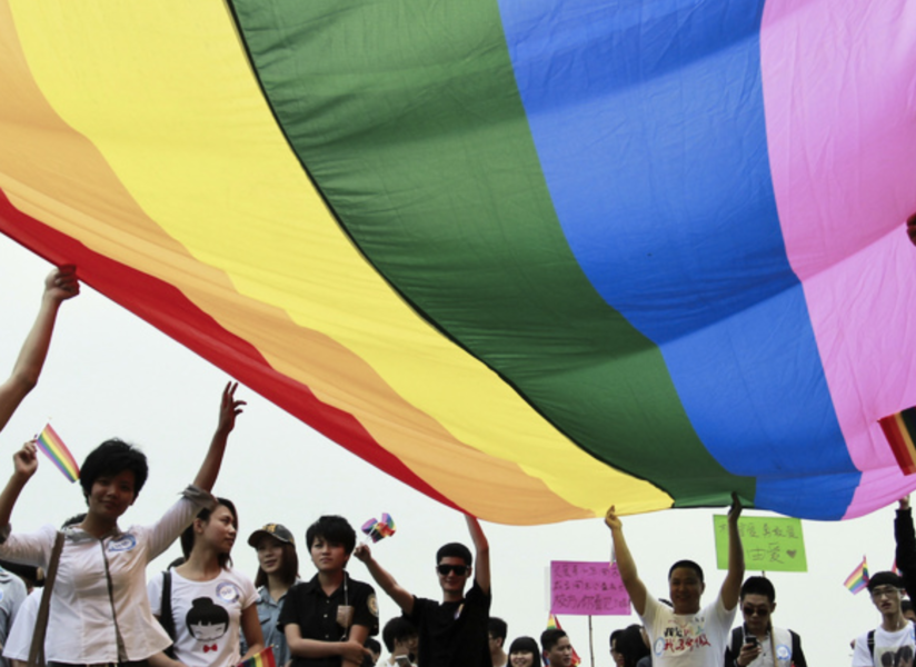 Hbtq-aktivister håller upp en regnbågsflagga i staden Changsha i södra Kina.