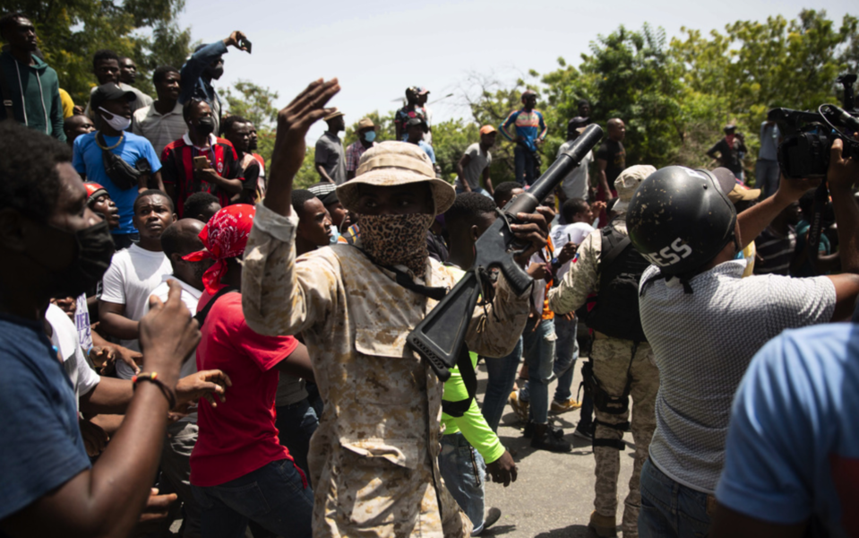 Poliser vid en samling människor som protesterar mot mordet på Haitis president.