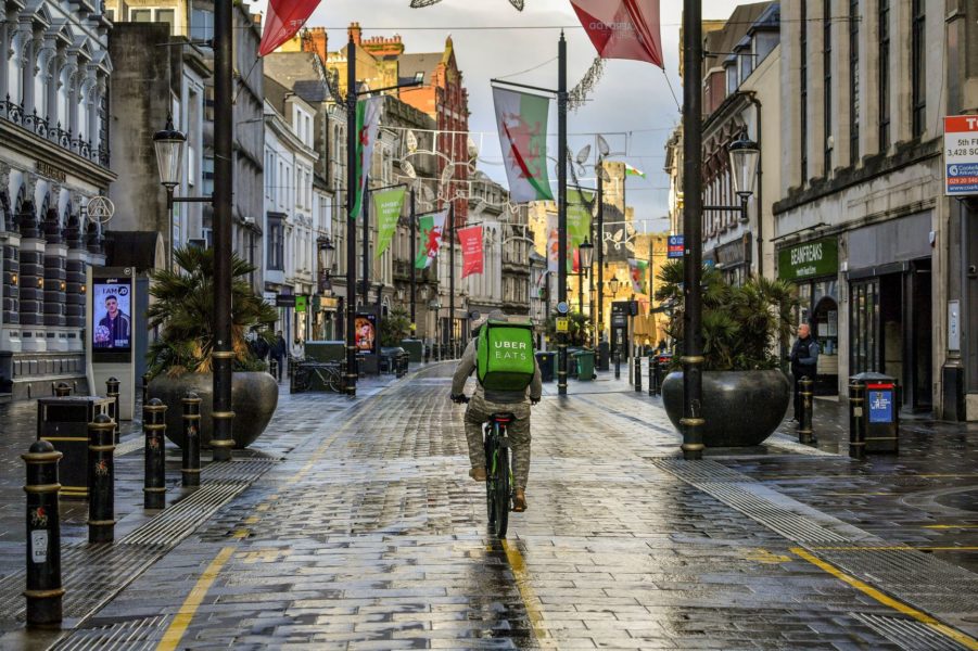 Ett matbud cyklar genom ett regnigt Cardiff i Wales.