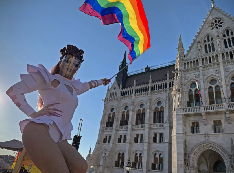 En dragqueen viftar med en regnsbågsflagga vid en hbtq-rättighetsdemonstration framför det ungerska parlamentet i Budapest i mitten av juni.