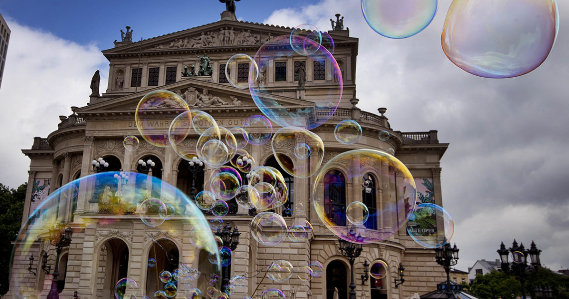 En såpbubbelartist visar upp sin bubbelkonst vid Gamla operan i Frankfurt.